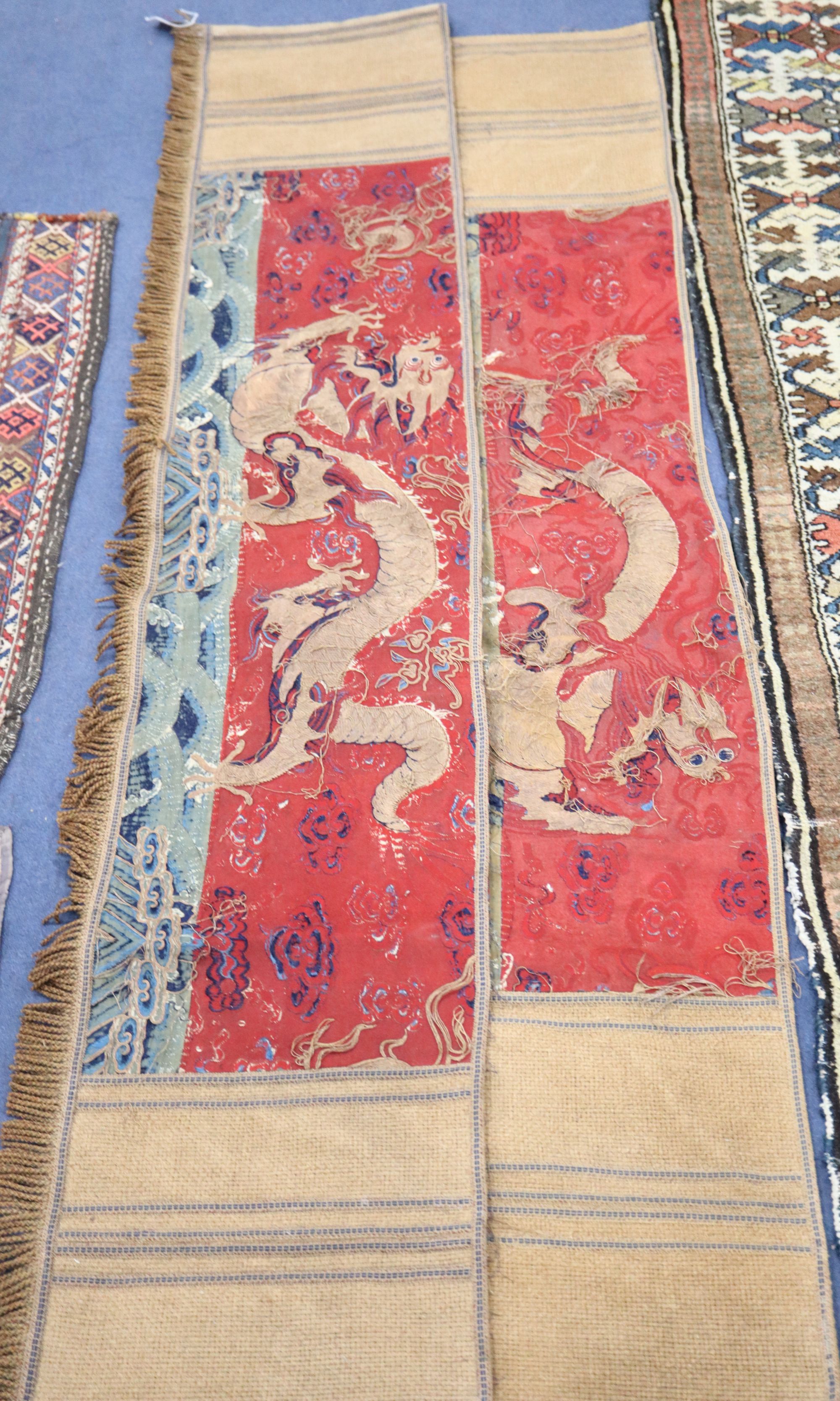 A pair of Antique Chinese silk and gold threadwork panels depicting dragons over waves, 38 x 150cm and 38 x 130cm, distressed and now